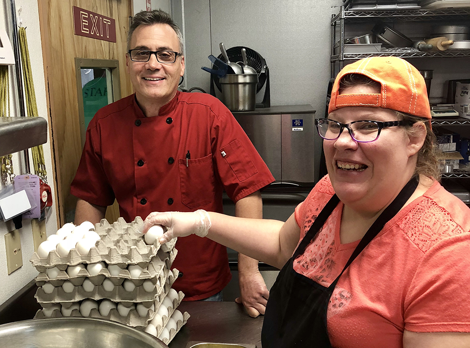 CHEF PHILIP WITH LIZ-960 Chef Phil of the Cookery works with a Civitan member in the kitchen.
